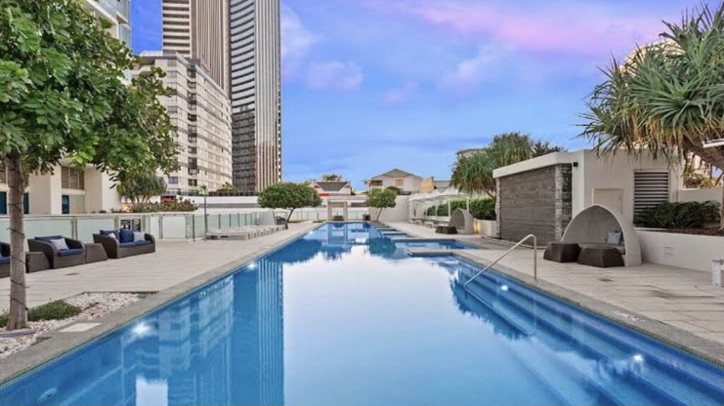 A serene swimming pool surrounded by modern buildings